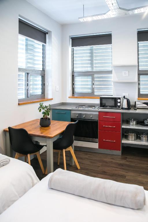 a kitchen with a table and a kitchen with red cabinets at Zeederberg Corner in Paarl