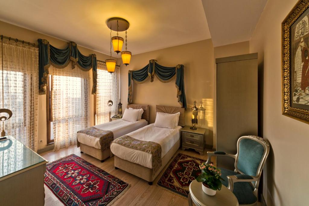 une chambre avec deux lits, une table et une chaise dans l'établissement Sokullu Pasa Hotel - Special Class, à Istanbul