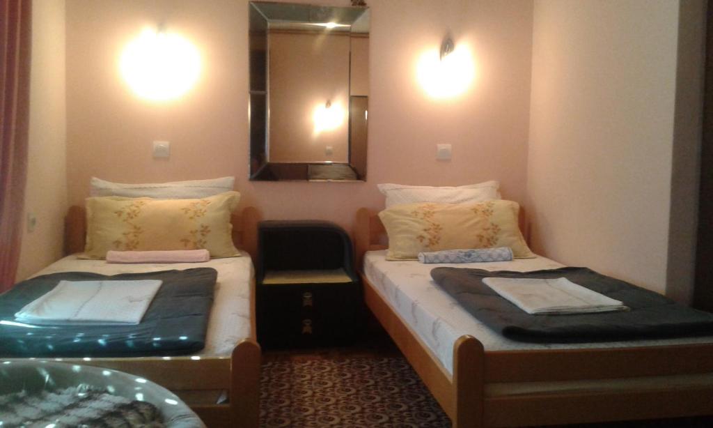 um pequeno quarto com 2 camas e um espelho em Apartman Vesna em Ovcar Banja