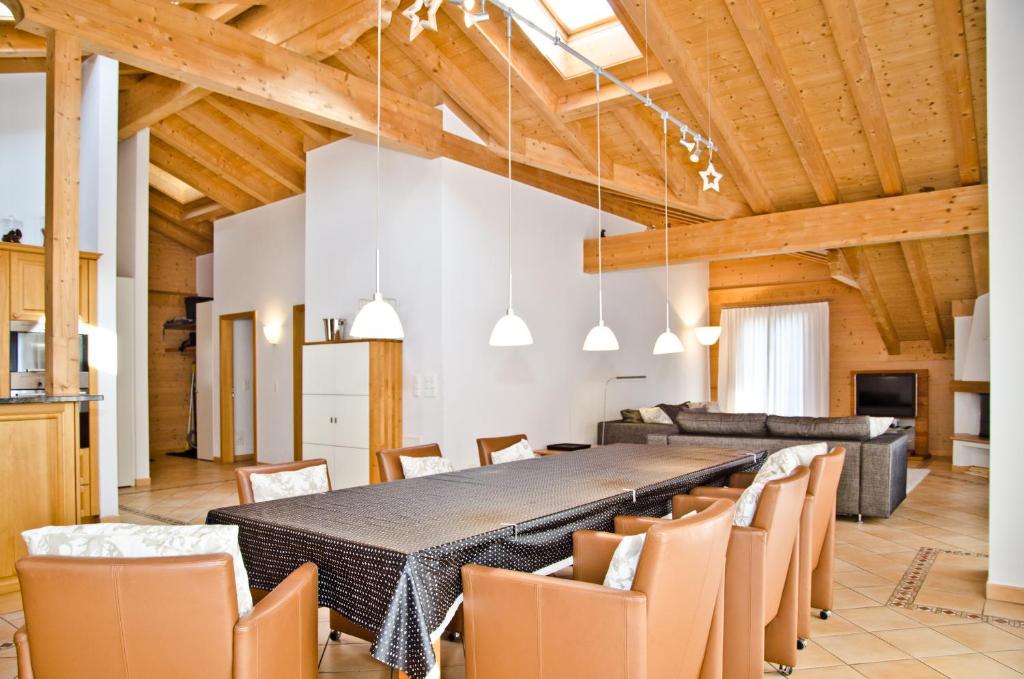 a dining room with a long table and chairs at Apartment Brunnen - GRIWA RENT AG in Grindelwald