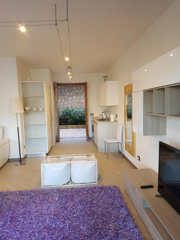 salon z fioletowym dywanem i kuchnią w obiekcie BMP APARTMENT DELUXE 2 JACUZZI RISCALDATA PRIVATA vista Lago di Garda w Brenzone sul Garda