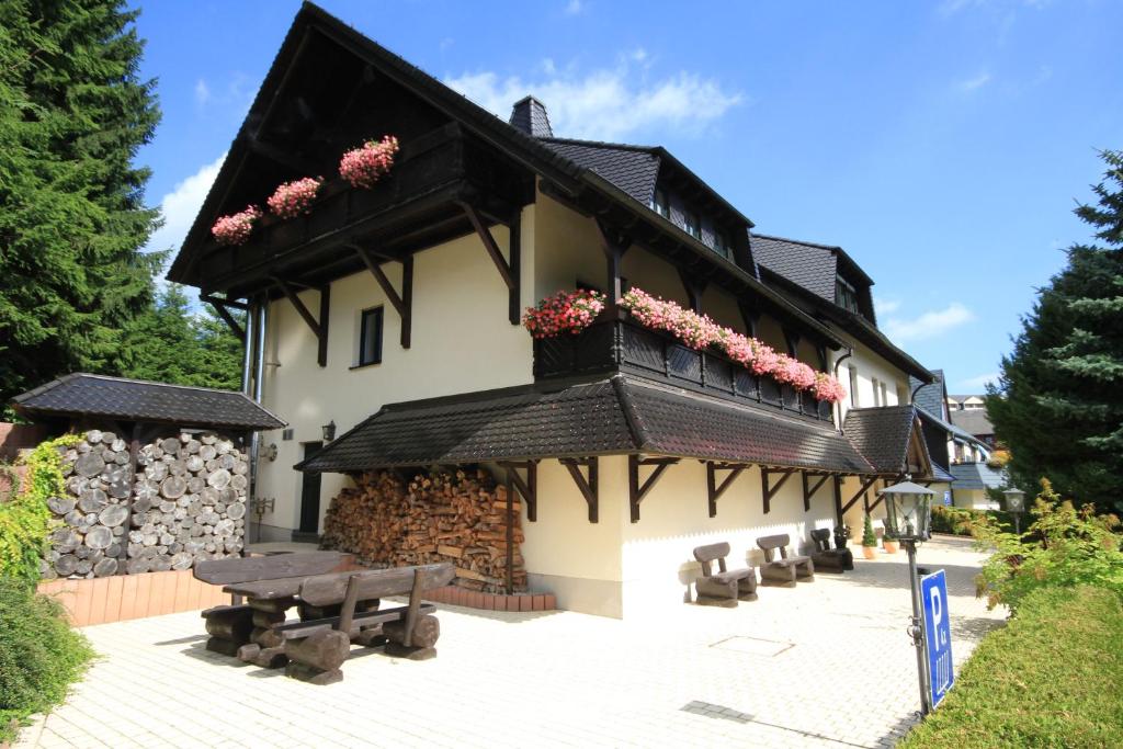 ein Gebäude mit einem Balkon mit Blumen darauf in der Unterkunft Appartementhaus am Fichtelberg in Kurort Oberwiesenthal