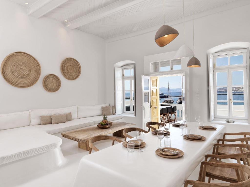 a white living room with a table and chairs at Villa Kampani Sea View Villa Mykonos Town in Mikonos