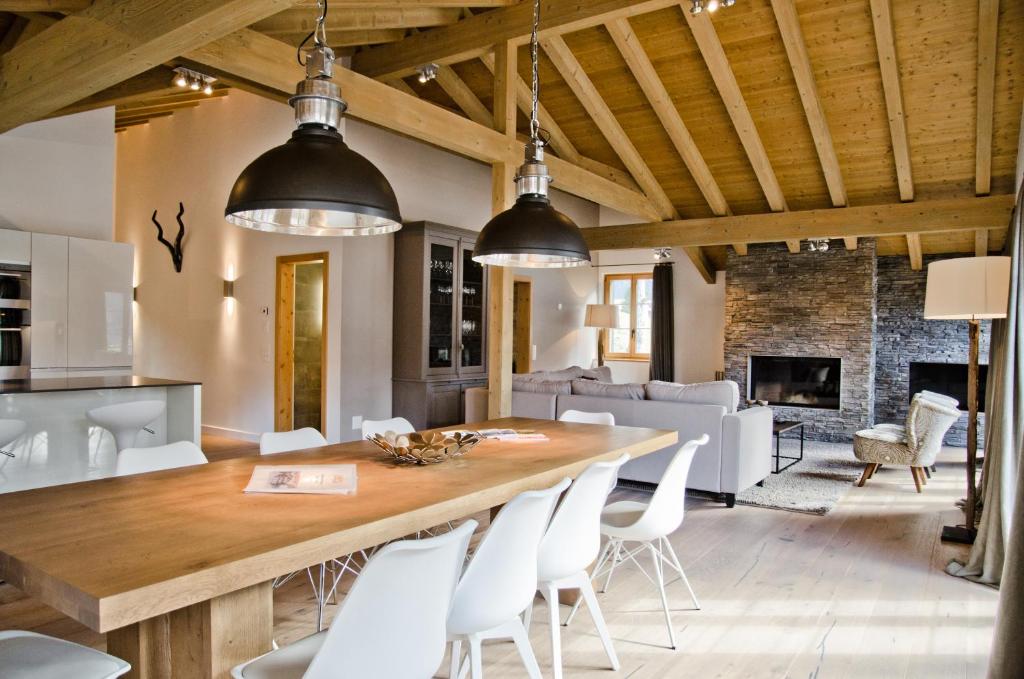 une cuisine et une salle à manger avec une grande table et des chaises en bois dans l'établissement Apartment Fortuna 5.5 - GriwaRent AG, à Grindelwald