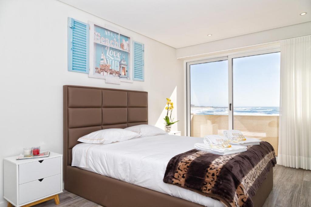 una camera da letto con un grande letto con una grande finestra di BestVillas Âncora Mar a Vila Praia de Âncora