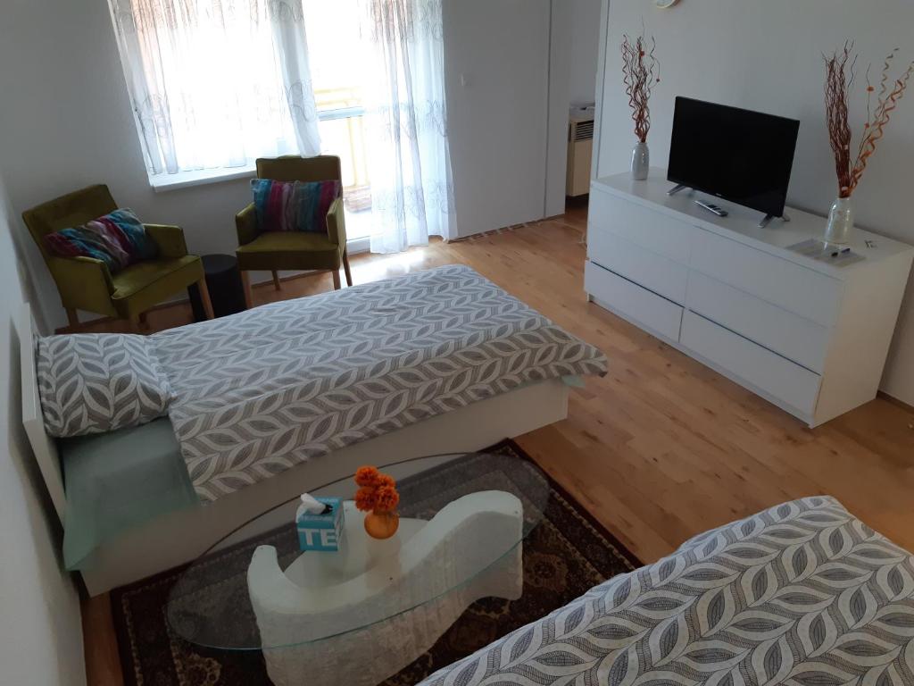 sala de estar con 2 camas y TV de pantalla plana en Apartment Nada, en Belišće