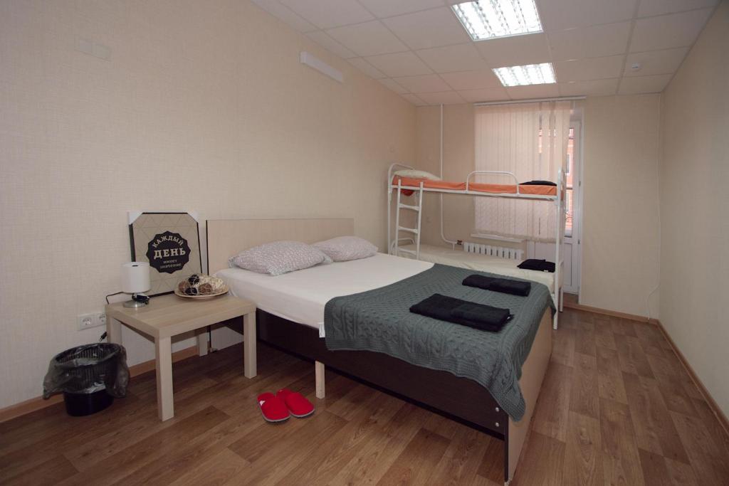 a bedroom with a bunk bed and a table with red shoes at Comfort Blizzzko Hostel in Kazan