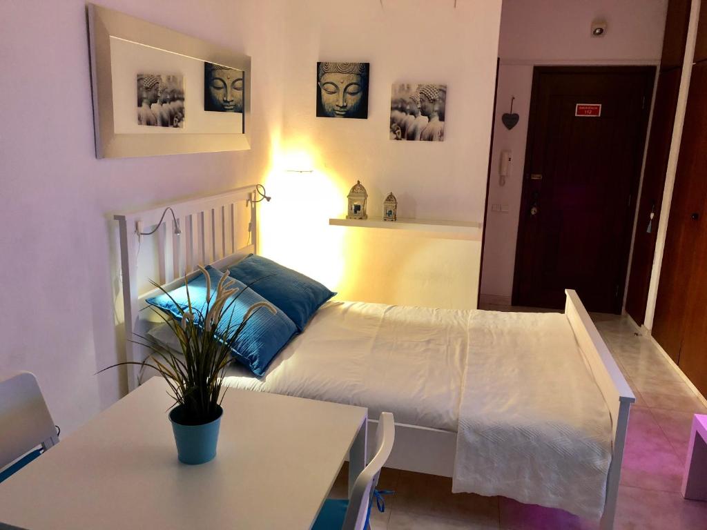 een slaapkamer met een wit bed en een tafel en een tafel sidx sidx bij Apartamento Praia do Alvor in Alvor