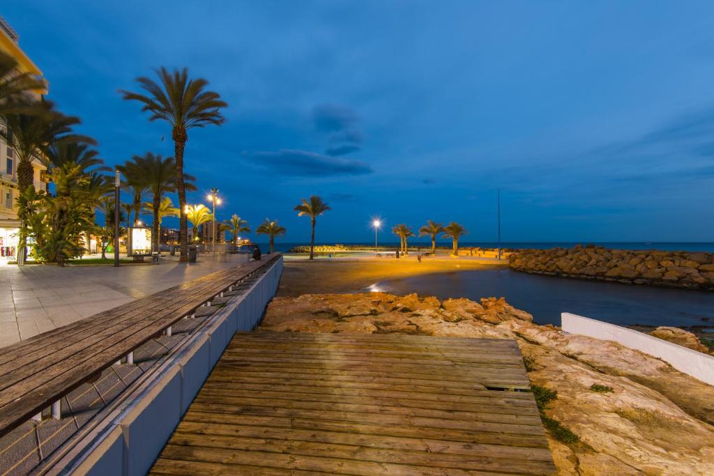 a boardwalk on the beach at night at Casas Holiday - Playa del Cura 1 in Torrevieja