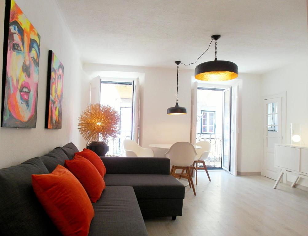 een woonkamer met een zwarte bank en oranje kussens bij SantoSweethome 2 in Lissabon