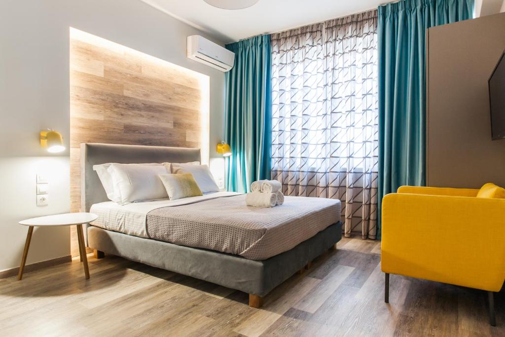 アテネにあるEnattica Syntagma Livingのベッドルーム1室(ベッド1台、黄色い椅子付)
