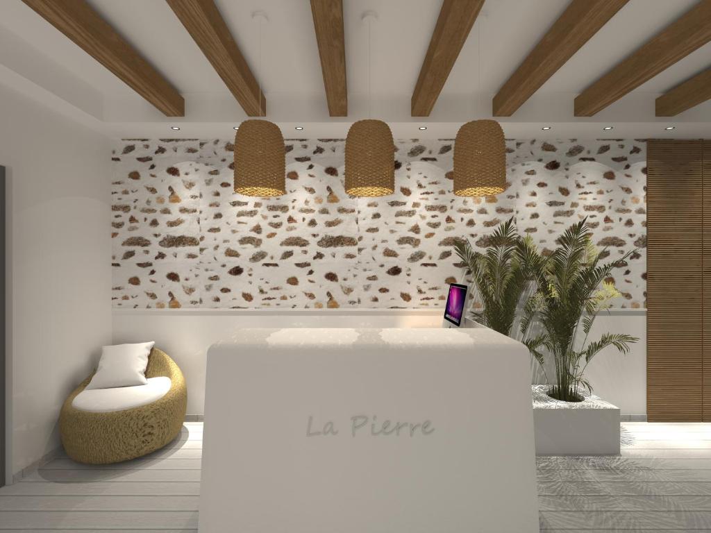 a lobby with a table and two pendant lights at La Pierre in Limenaria