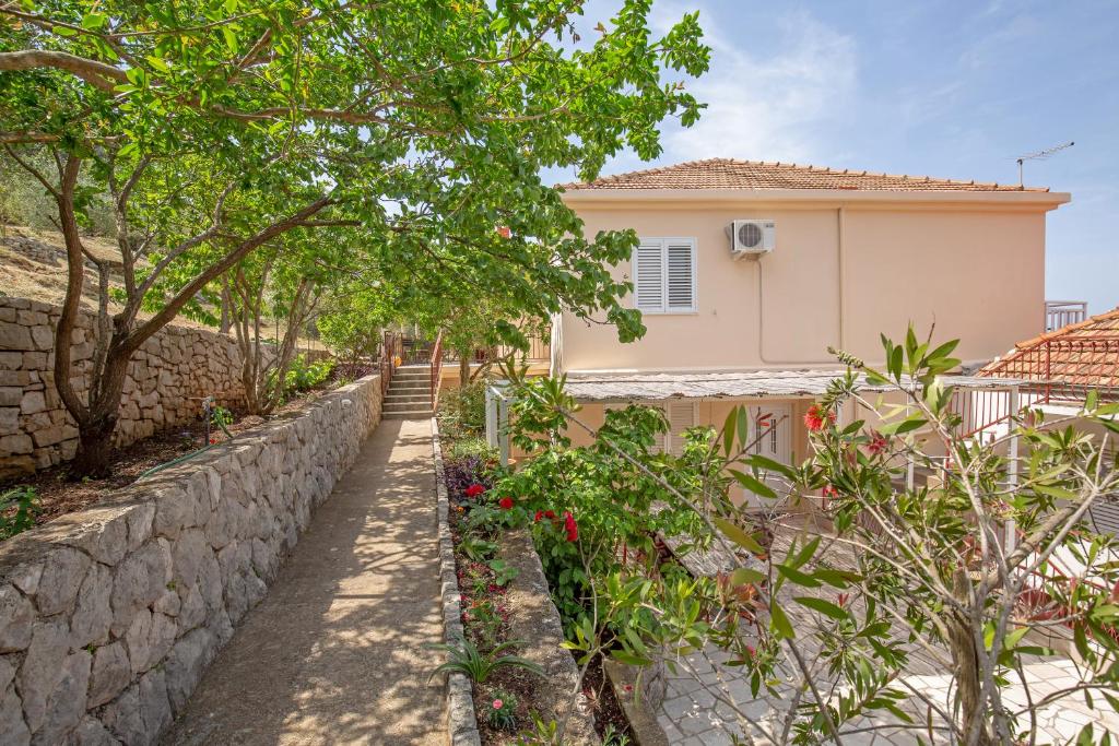 a stone retaining wall next to a house at Apartments Elica in Koločep