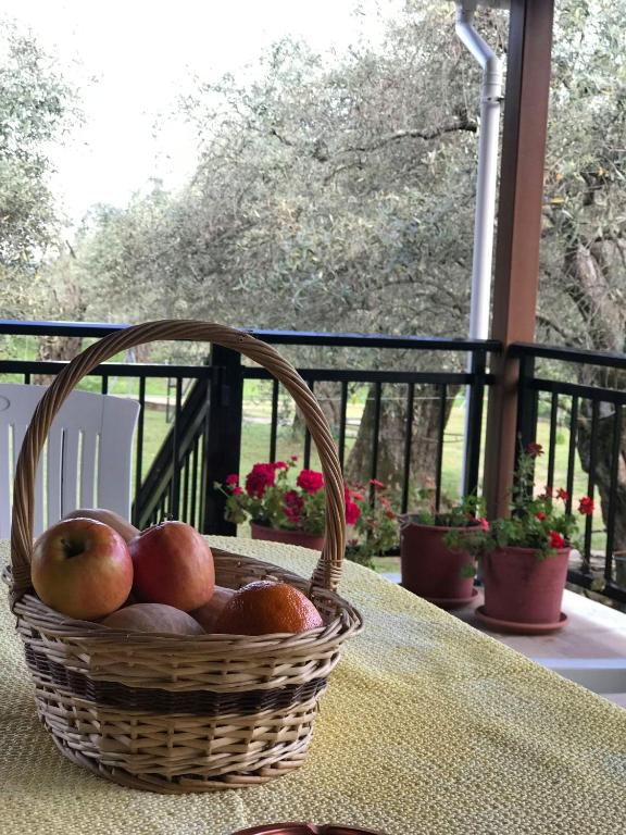 a basket of apples sitting on a table on a porch at Lucky Farm House in Potamiá
