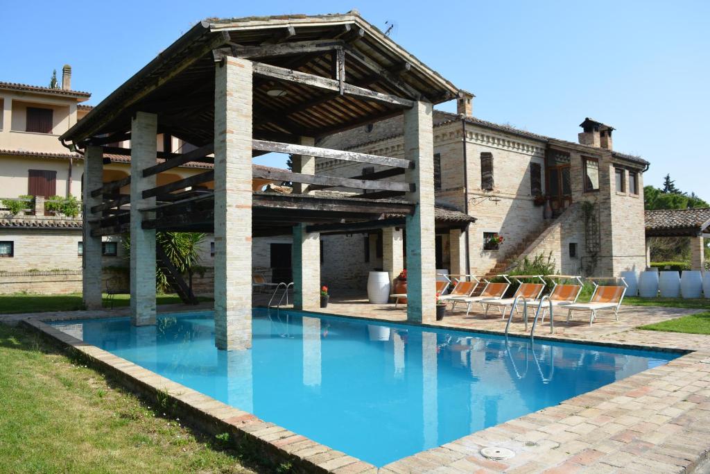 a swimming pool in front of a house at La casa nella Vigna in Montegranaro