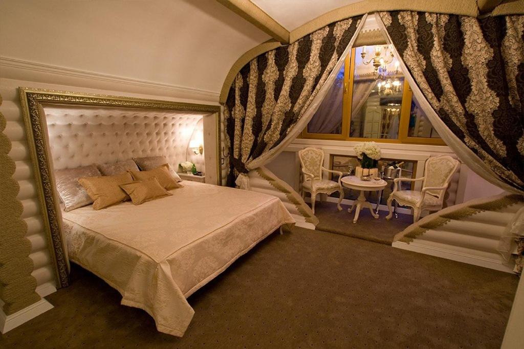 um quarto com uma cama, uma mesa e uma janela em Загородный отельно-ресторанный комплекс "Четыре сезона" em Filippovichi