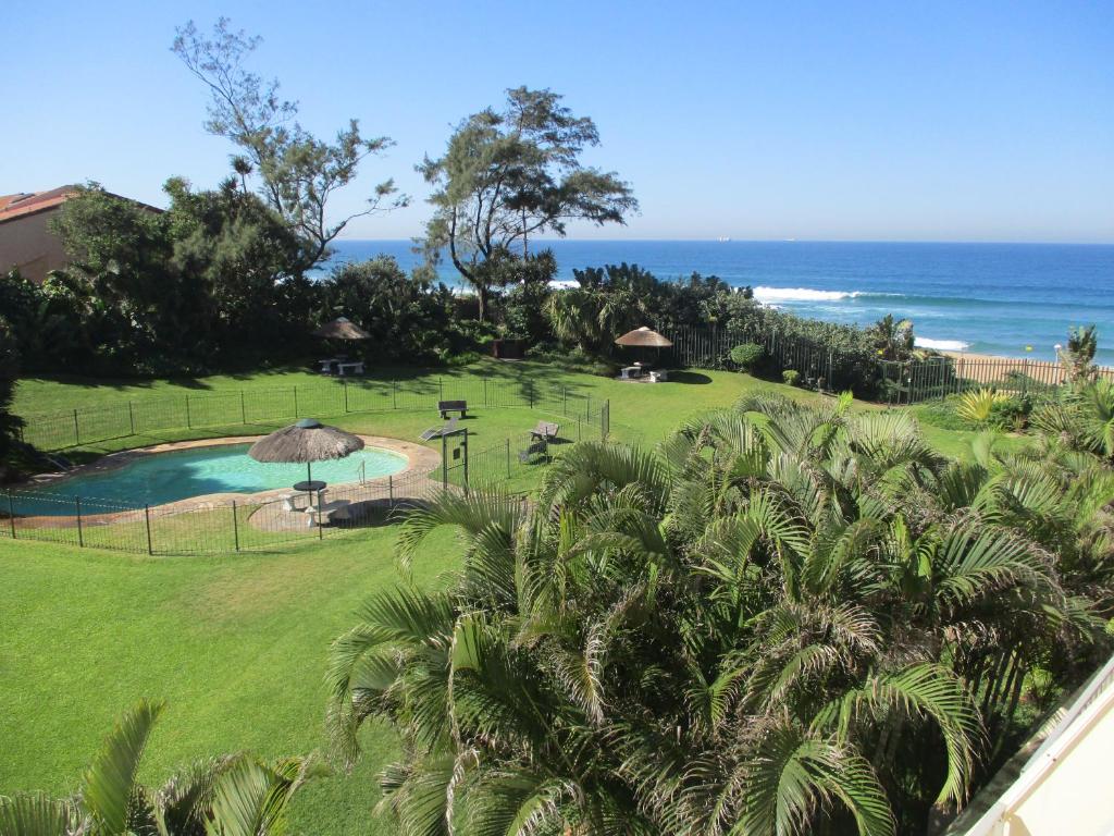 a view of a resort with a swimming pool and the ocean at 22 Kyalanga Beachfront Apartment in Durban