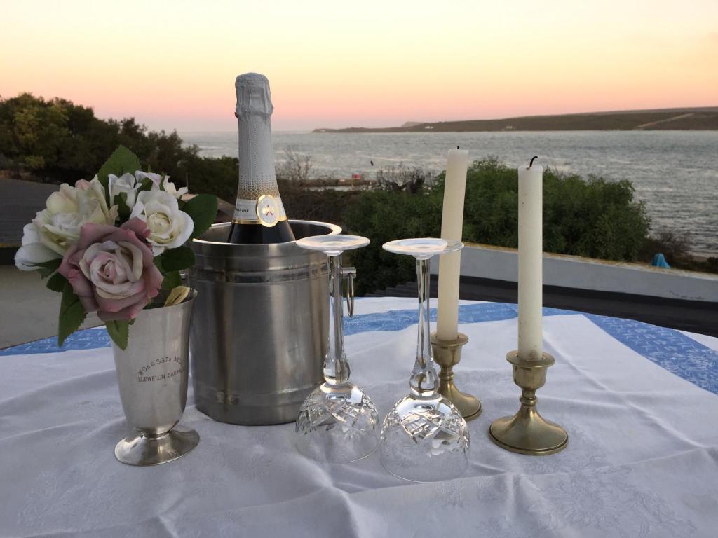 una mesa con una botella de vino y velas en Waterford Holiday Home, en Witsand