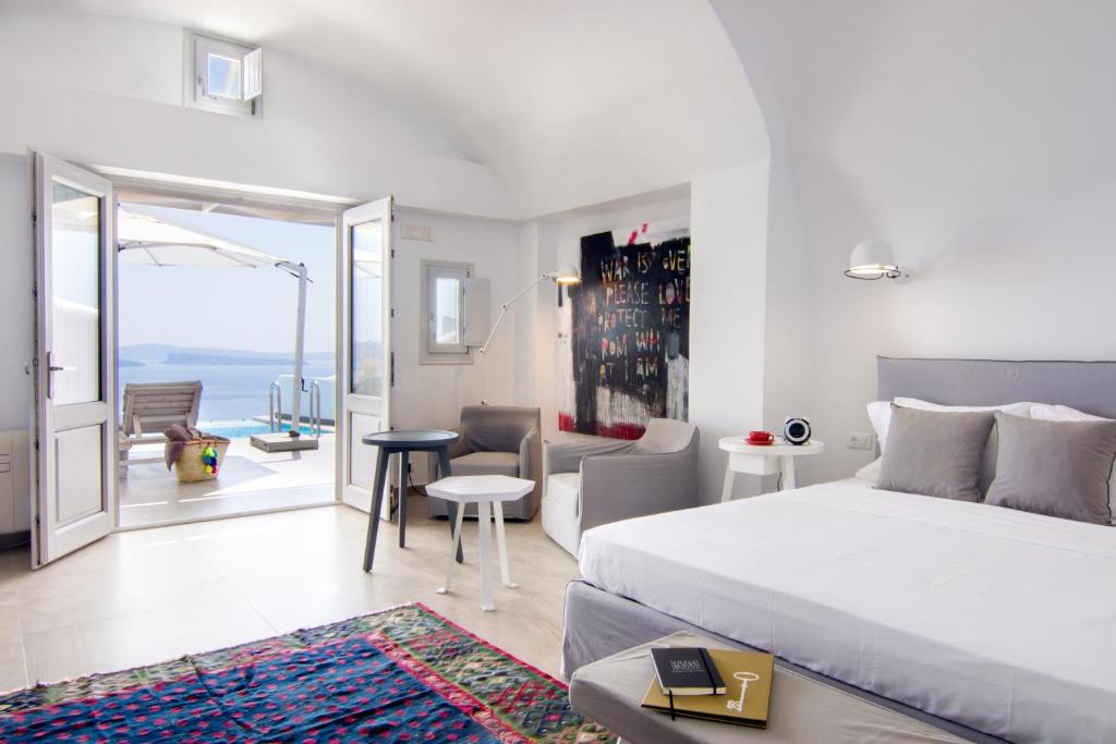 a living room filled with furniture and a large window at Santorini Secret Suites & Spa, Small Luxury Hotels of the World in Oia
