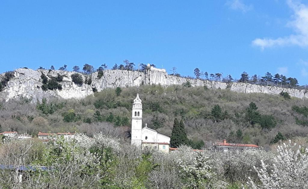 une église blanche au sommet d'une montagne dans l'établissement Relax in Črni Kal, à Črni Kal