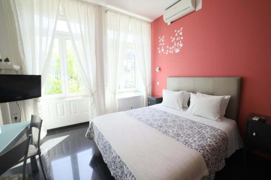 波多的住宿－品霍公寓、一室公寓和客房旅館，一间卧室设有一张床和红色的墙壁