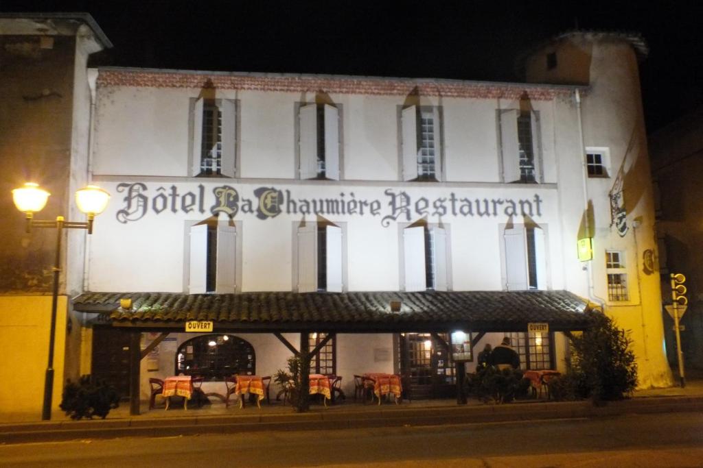 a building with a sign for a restaurant at night at Hotel Chaumiere - in Tournon-sur-Rhône