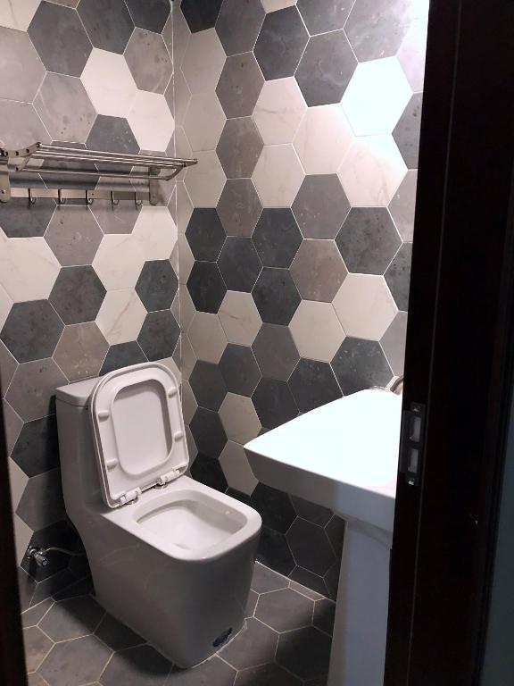 a bathroom with a toilet and a sink at Saipan Skyline Designers Hotel in Saipan