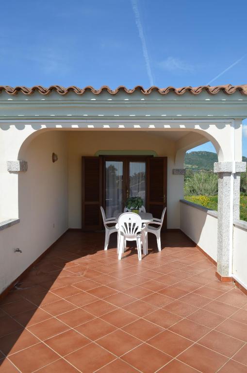 patio ze stołem i krzesłami na domu w obiekcie ISS Travel, Ambra apartments - 800 m from La Cinta beach w mieście San Teodoro