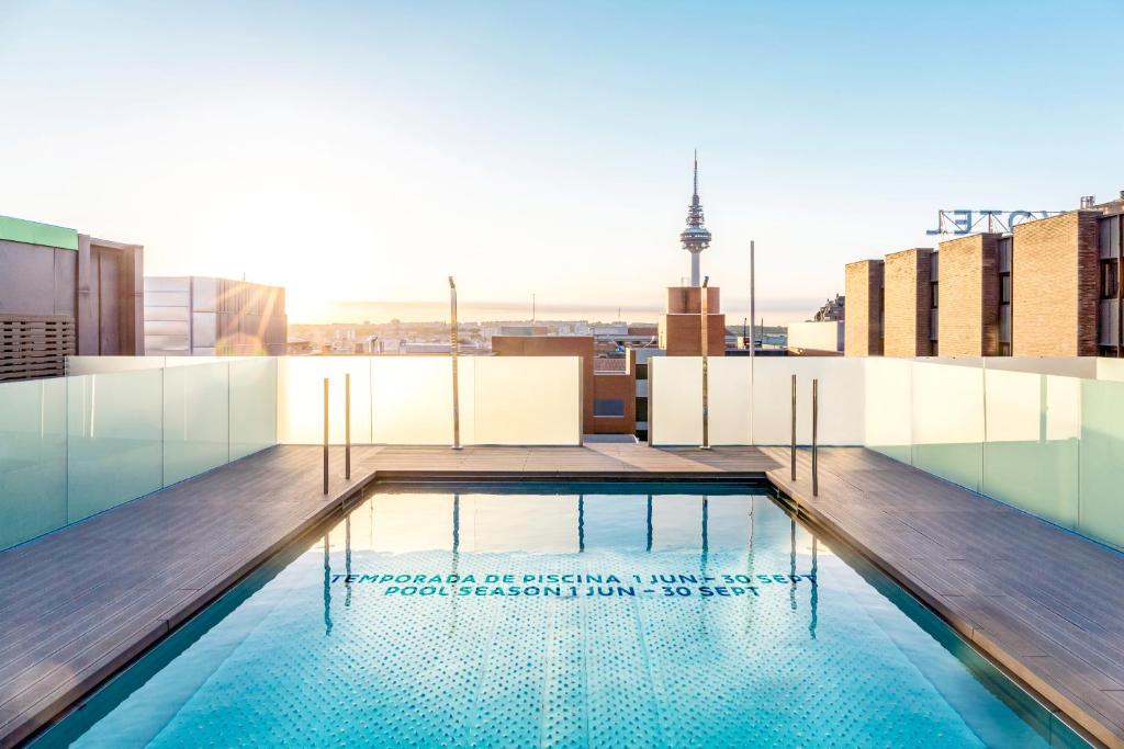 a swimming pool on the roof of a building at Novotel Madrid Center in Madrid