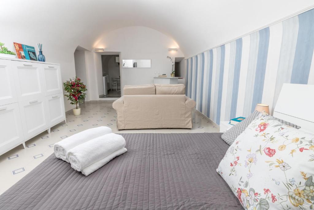 a bedroom with a bed and a couch and a chair at To Be Capri in Capri