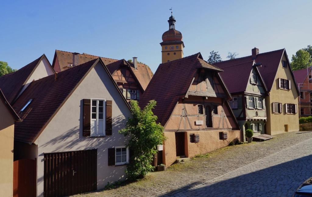 een oud gebouw met een klokkentoren op een straat bij Feriendomizil Dinkelsbühl in Dinkelsbühl