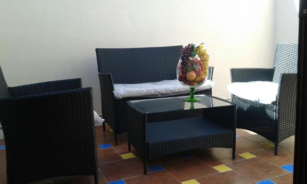 a table and chairs with a bowl of fruit on it at Pettinato in Portopalo