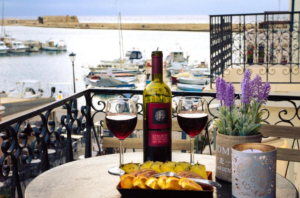 una bottiglia di vino e due bicchieri su un tavolo di Casa Ithomi a Chania