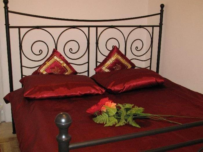 ピアセチュノにあるPiaseczno Willa Staropolskaの赤い枕と花が飾られたベッド