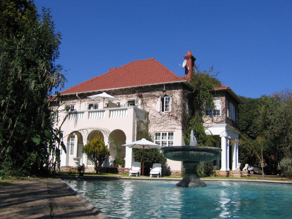 a large house with a fountain in front of it at Villa Victoria executive Guest House in Benoni