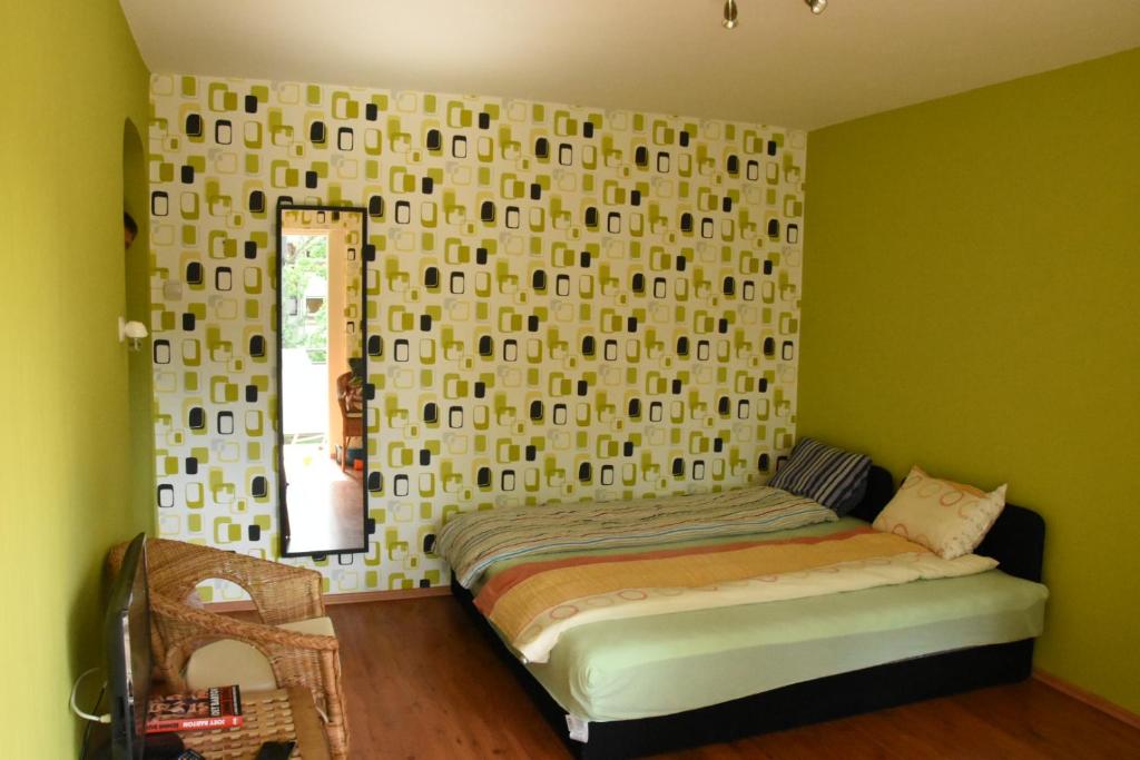 een slaapkamer met een bed en een muur met een spiegel bij Lovely apartment at Balatonfenyves in Balatonfenyves