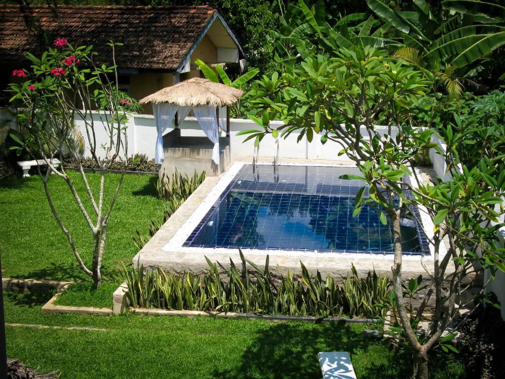 a small swimming pool in a yard with a house at Pavana Resort in Embilipitiya