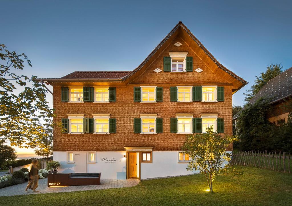 a large brick house with a gambrel roof at Mesmerhaus in Bildstein