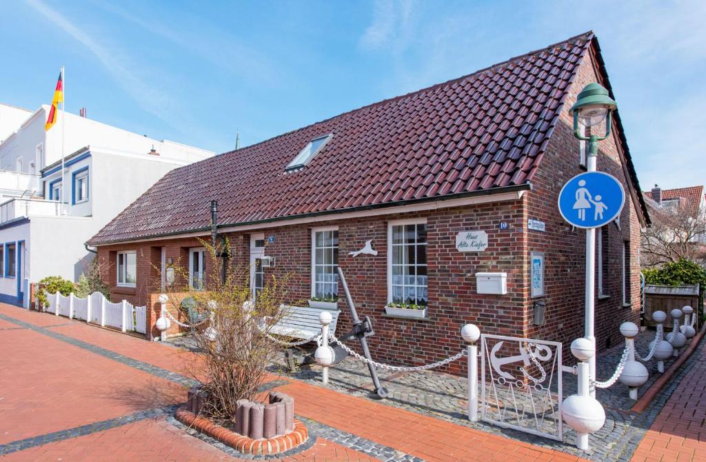 un piccolo edificio di mattoni con un cartello blu sopra di Haus Alte Kiefer Whg 2 a Norderney