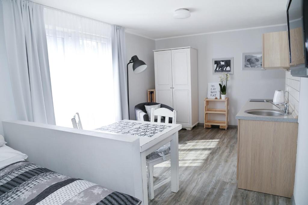 a bedroom with a white desk and a kitchen at 4 STRONY ŚWIATA Dom Gościnny in Dźwirzyno