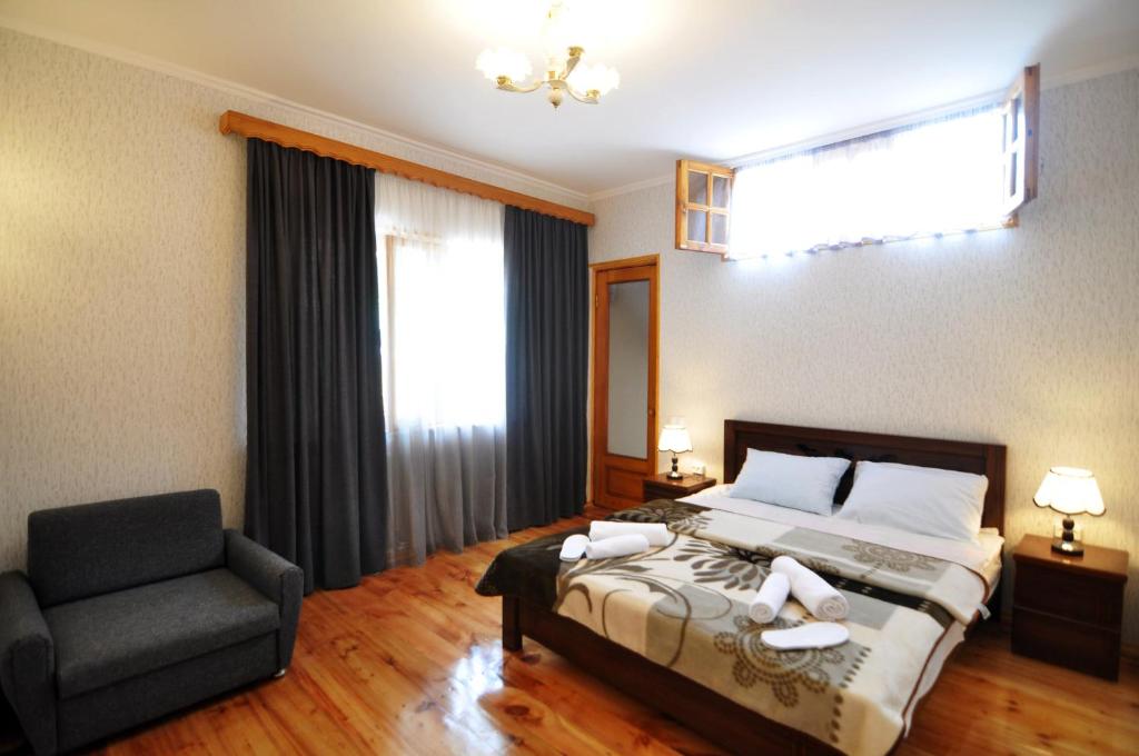ein Schlafzimmer mit einem Bett, einem Stuhl und einem Fenster in der Unterkunft Mia's Apartment in Tbilisi City