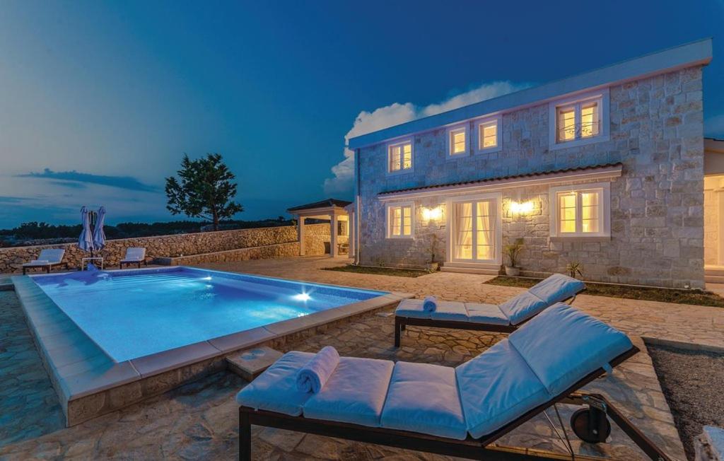 a large swimming pool in front of a house at Villa Toma I in Novalja