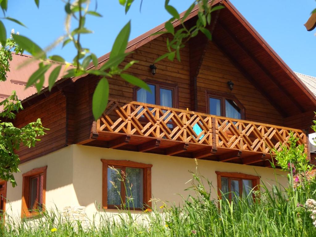ein Haus mit einem Holzbalkon darüber in der Unterkunft Котедж-шале Елітний in Slawske