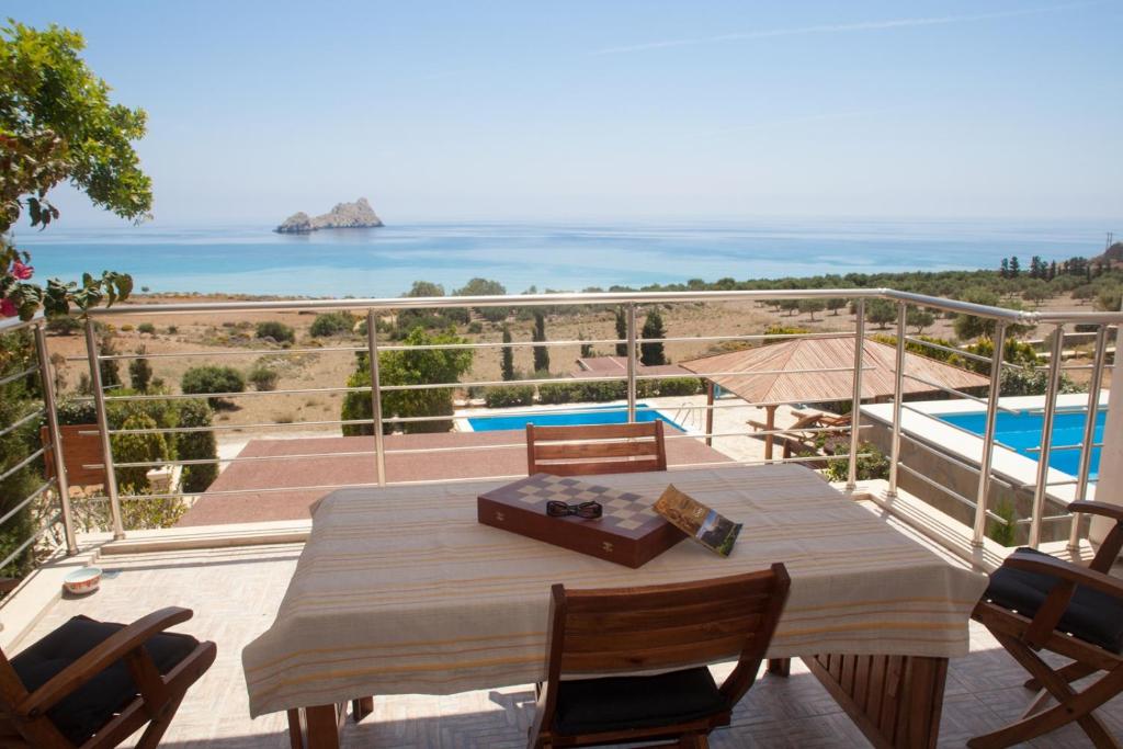 a table on a balcony with a view of the ocean at Krinakia Villas in Xerokampos