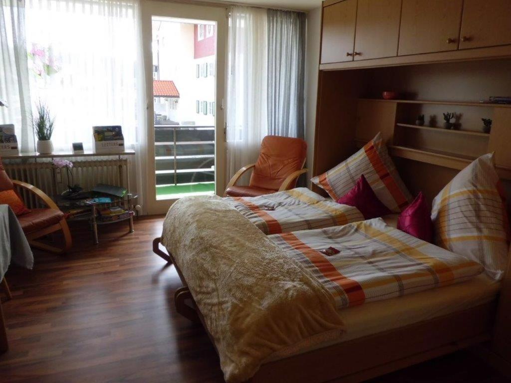 - une chambre avec un grand lit et une grande fenêtre dans l'établissement kloi und scheee, à Oberstaufen