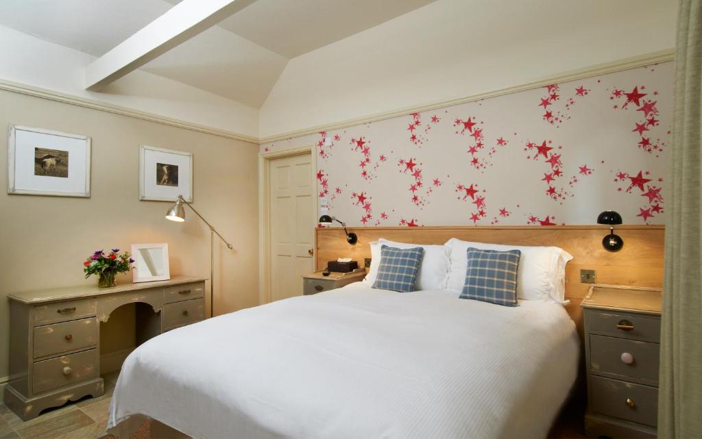 FarnhamにあるThe Museum Innのベッドルーム1室(赤い花の壁に大きな白いベッド1台付)