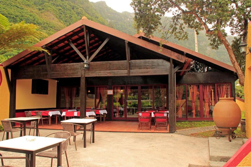 un pavillon avec des tables et des chaises en face d'un bâtiment dans l'établissement Casa Reis, à Santana