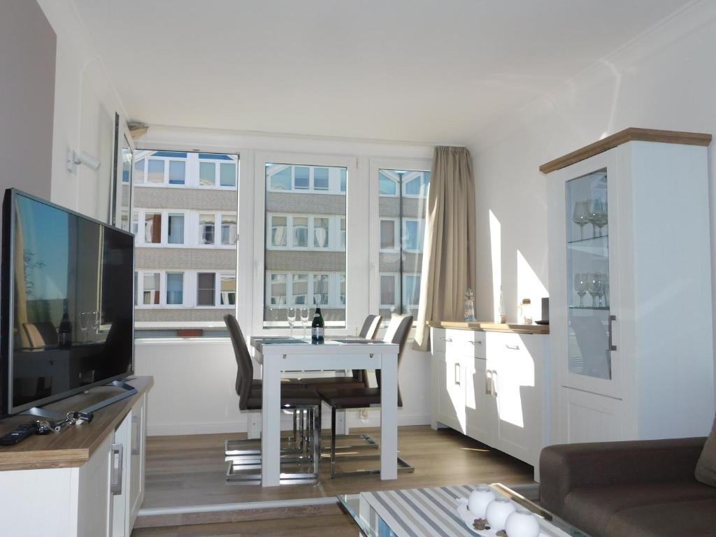 a living room with a white table and chairs at Nordsee in Nordstrand