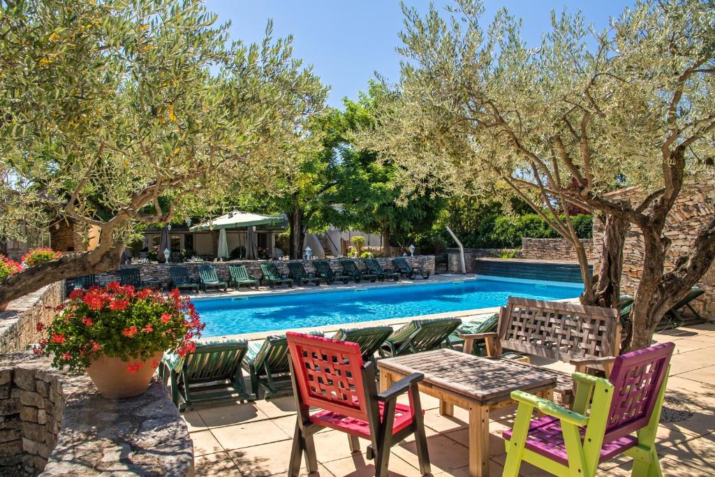 a patio with a table and chairs next to a pool at L'Escarbille in Saint-Martin-dʼArdèche