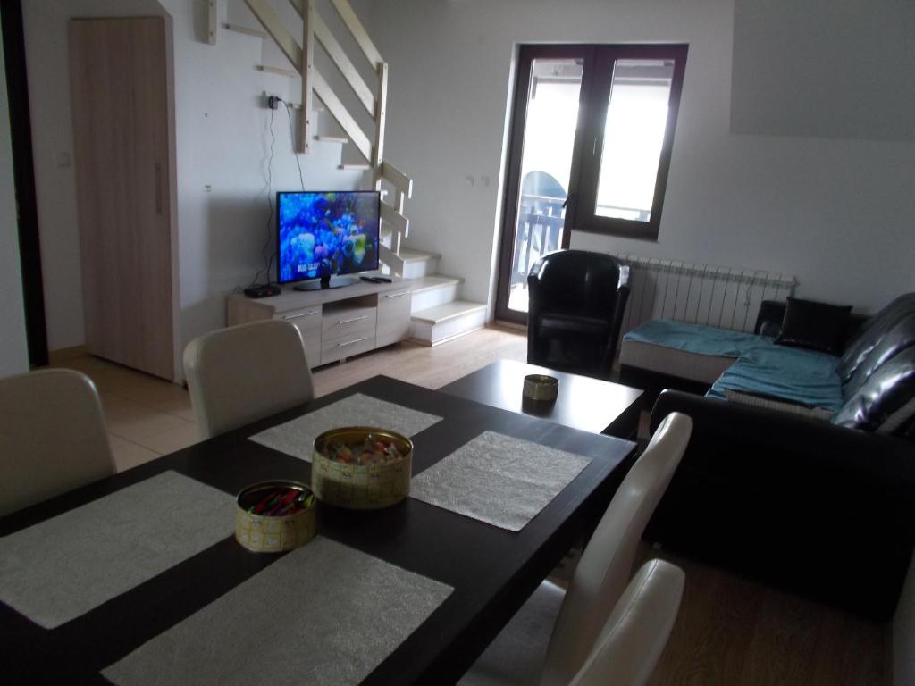 a living room with a dining table and a television at Gorštak in Kopaonik